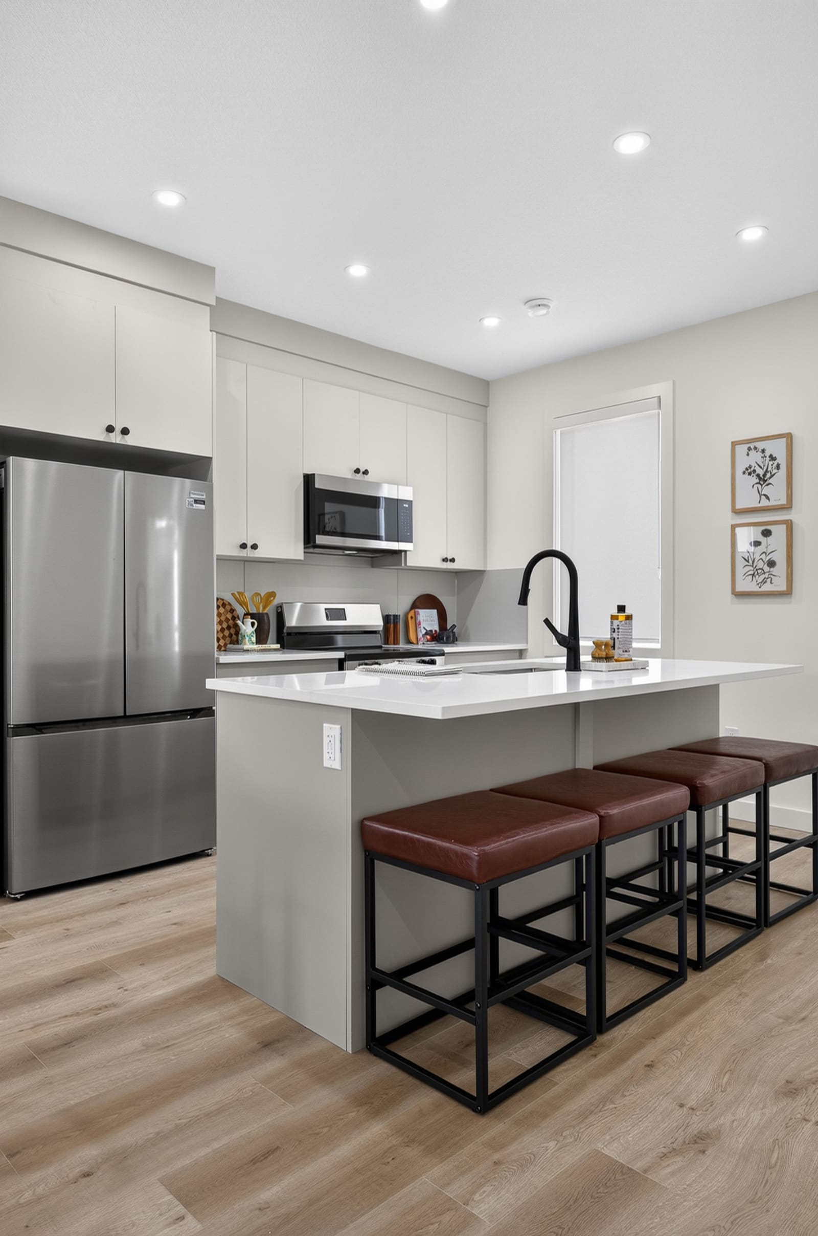 Show home kitchen with island, stools and included appliances