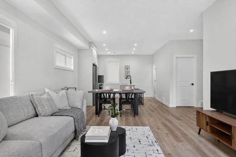 Staged living room in the show home with sectional sofa and media console